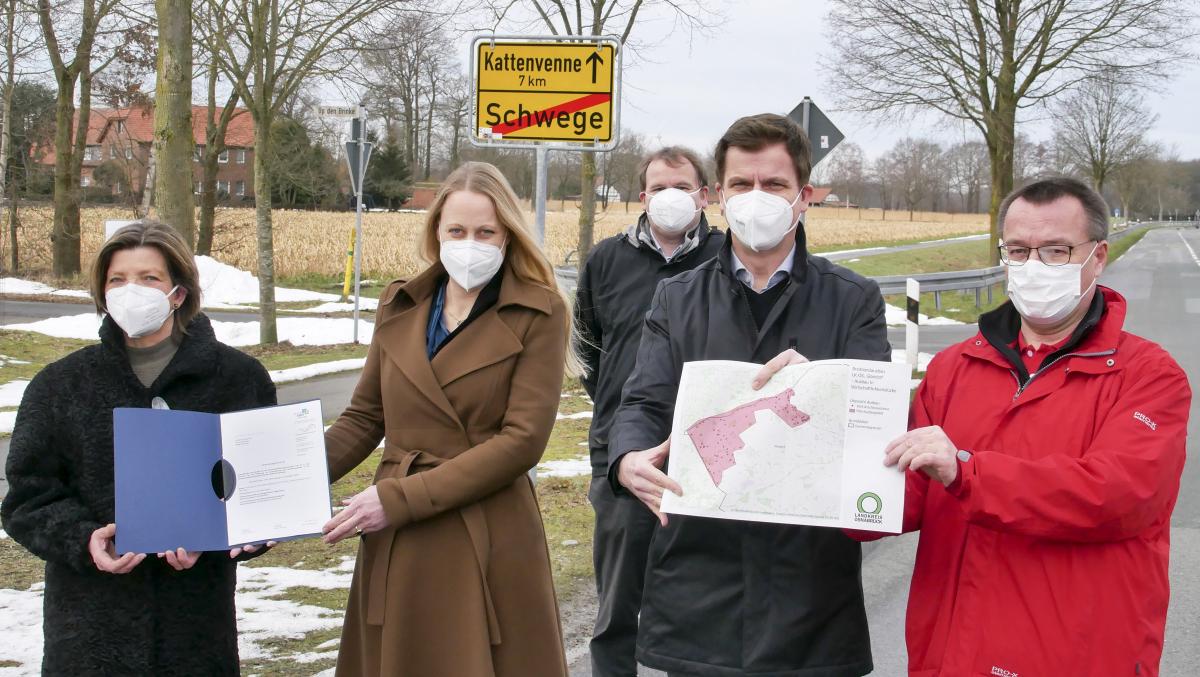 5 Personen im Freien, 2 halten eine Urkunde in die Kamera