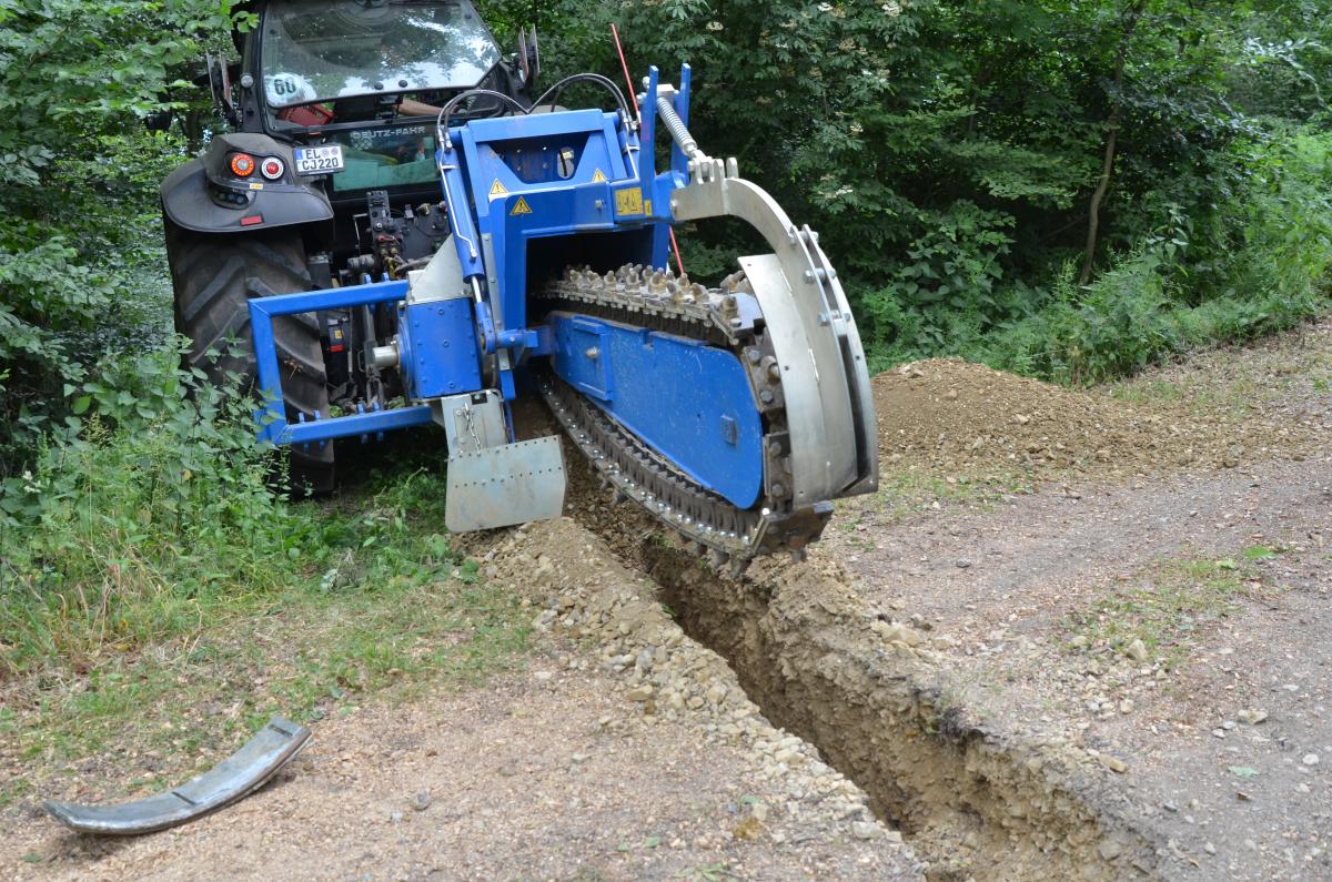 Eine Baumaschine steht an einem Waldweg.