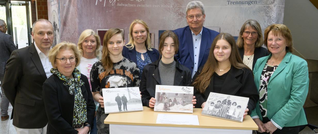 Gruppe von Personen vor Stellwand