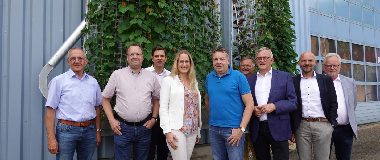 Gruppe von Personen vor Fabrikgebäude