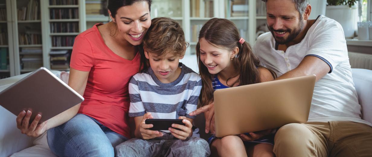 Familie auf Sofa mit Laptop