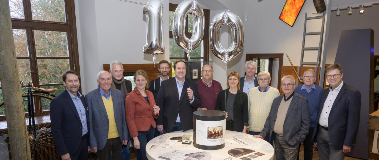 Eine Personengruppe steht in einem Ausstellungsraum.