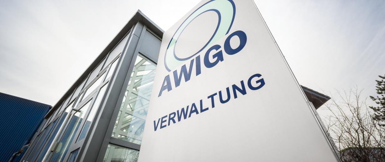 Firmenschild mit der Aufschrift AWIGO vor einem Gebäude