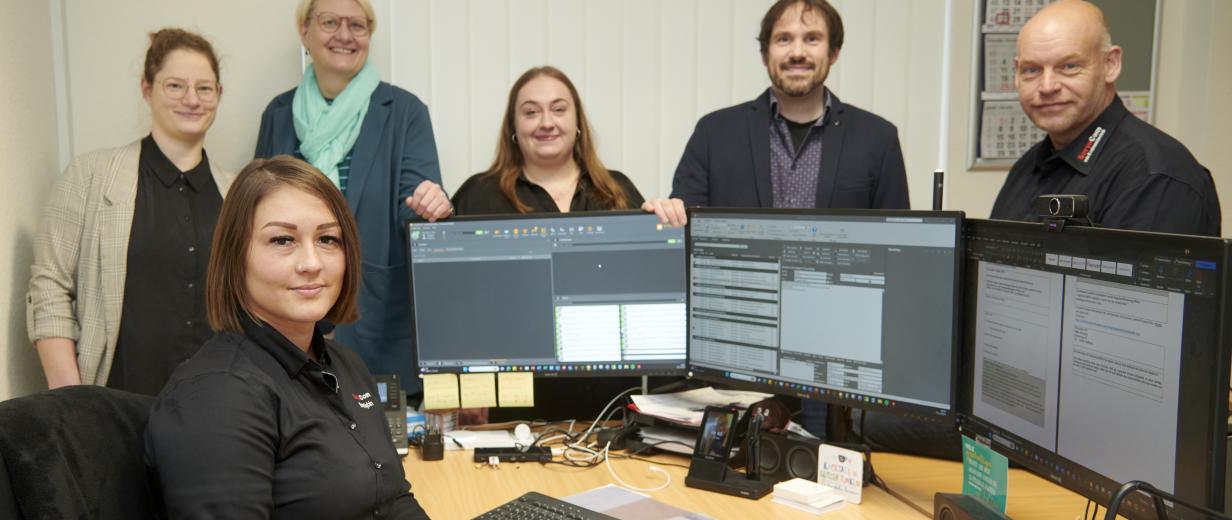 Gruppe von Personen im Büro vor PCs