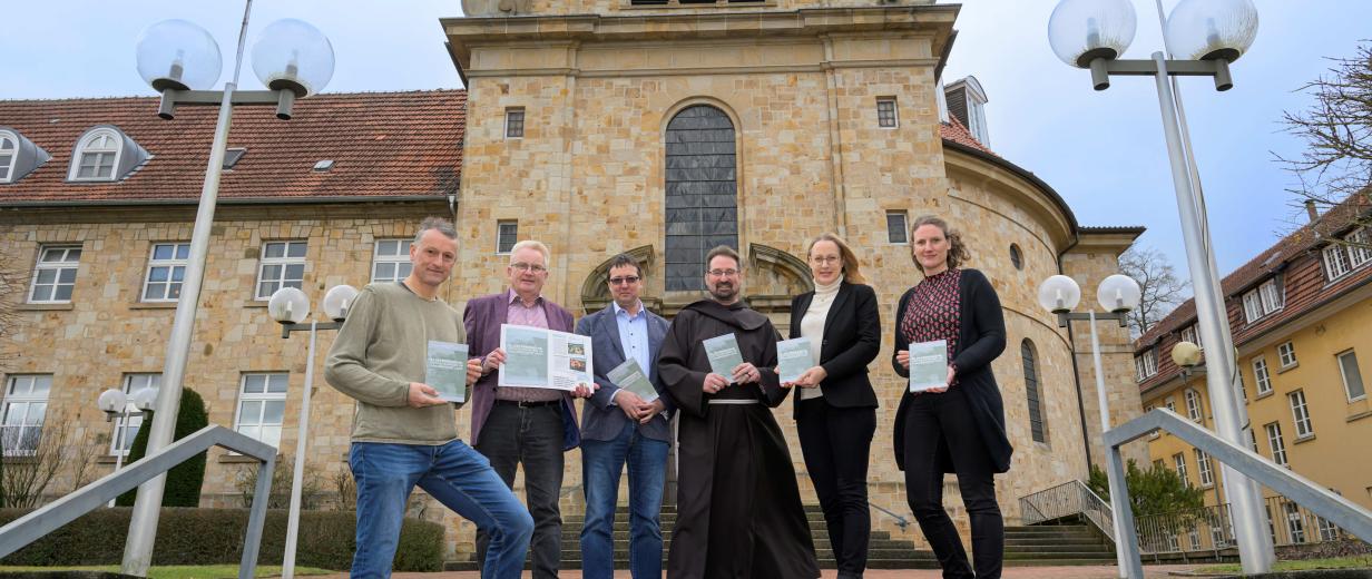 Gruppe von Personen vor Klostergebäude