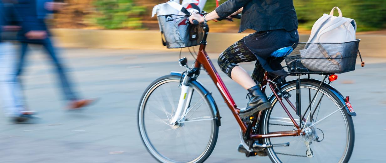 Person mit Fahrrad auf Radweg. Andere Person kommt zu Fuß entgegen.