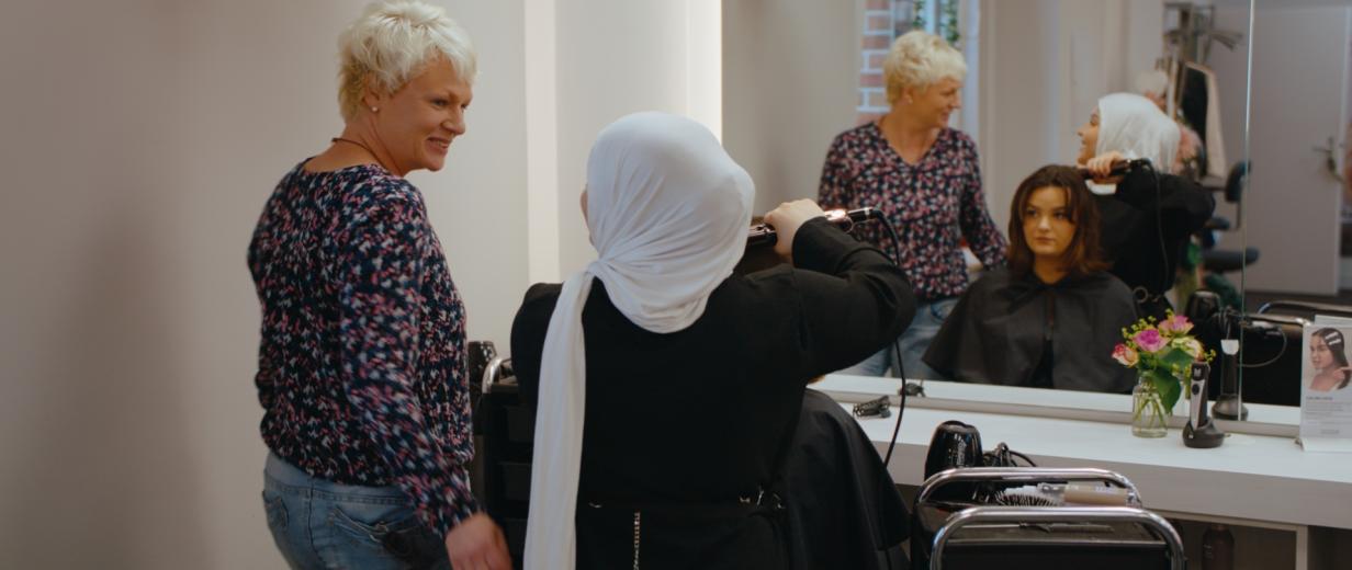 Drei Personen in einem Friseursalon