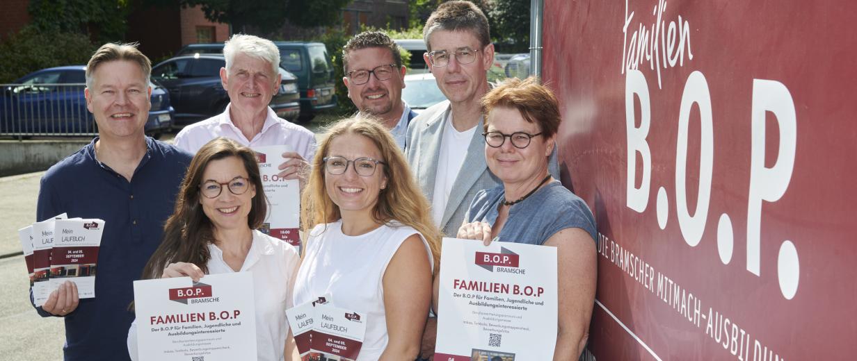 Gruppe vor Personen vor Plakat