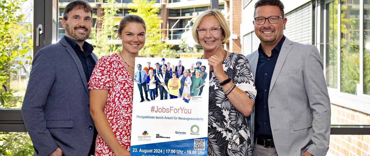 4 Personen im Freien mit Plakat