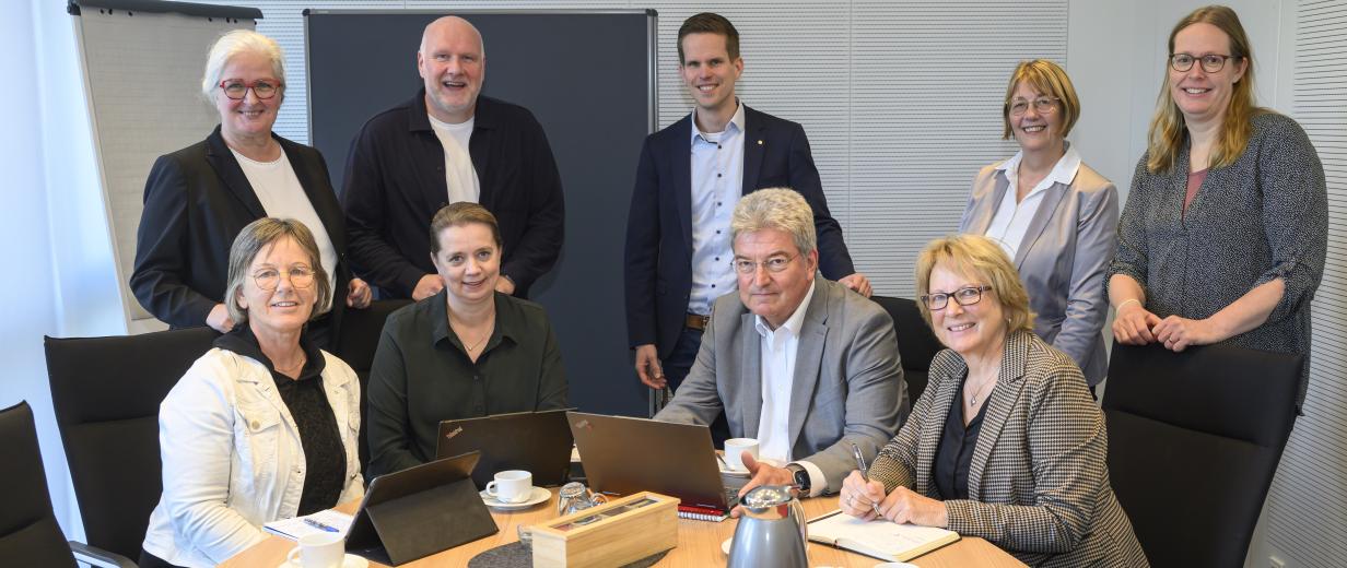 9 Personen vor einem Tisch