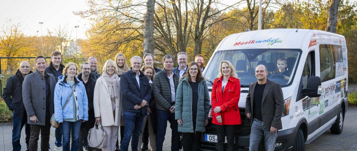 Gruppe von Personen vor Transporter