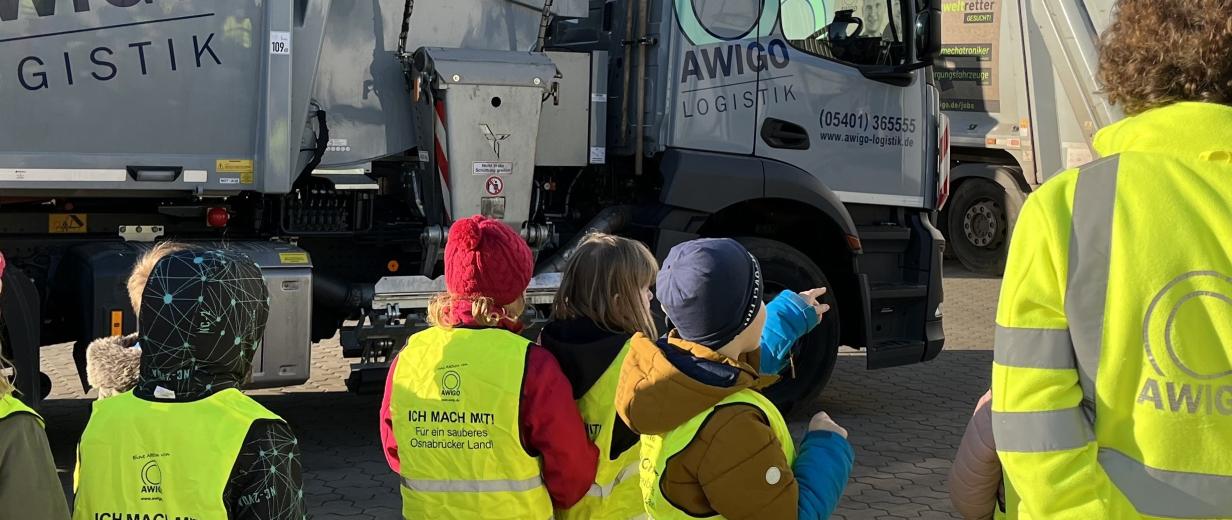 Eine Kindergruppe vor einem Müllfahrzeug