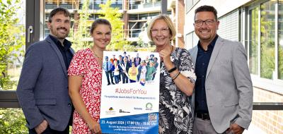 4 Personen im Freien mit Plakat