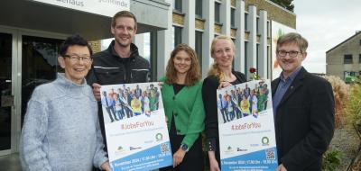 Gruppe von Personen mit zwei Plakaten im Freien