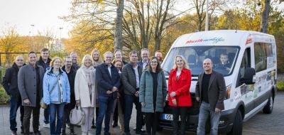 Gruppe von Personen vor Transporter