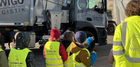 Eine Kindergruppe vor einem Müllfahrzeug