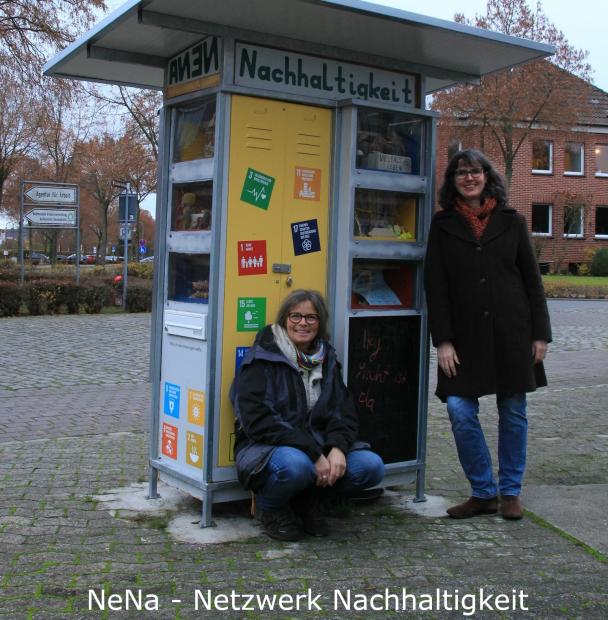 Zwei Personen stehen auf einer Straße an einem Schrank.