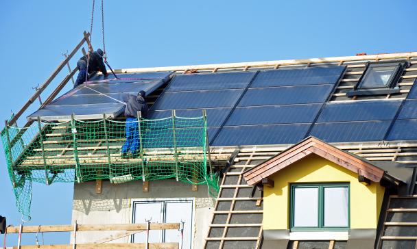 Solarpanele werden auf einem Hausdach montiert.